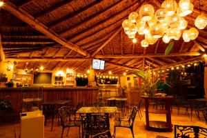a restaurant with tables and chairs and chandeliers at Glamping estilo Hobbit in Curití