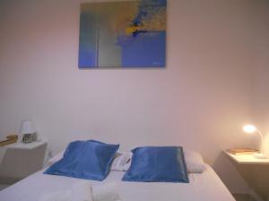 a bedroom with a bed with blue pillows on it at Apartamento vista ao mar com ar in Salvador