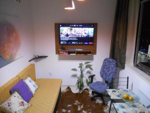 a living room with a couch and a tv on the wall at Apartamento vista ao mar com ar in Salvador