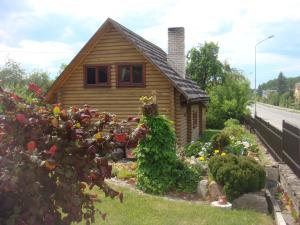 una pequeña casa con un jardín frente a ella en Vila Marta, en Druskininkai