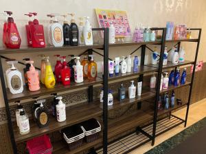 a shelf filled with lots of bottles of soap and shampoo at ホテルセリーヌ adult only in Tenri