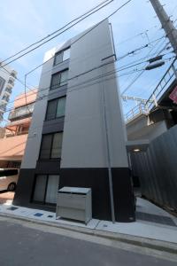 a white building with a bench in front of it at Cozy Nest Yokohama 横浜駅徒歩10分 Brand New Up to 4 Guests in Yokohama