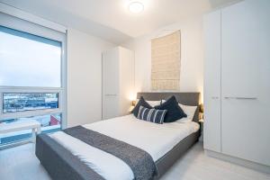 Un dormitorio con una cama y una ventana grande. en Modern Suite by Olympic Village SkyTrain Sleeps 3, en Vancouver