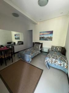 ein Zimmer mit zwei Betten und einem Tisch und einem Schreibtisch in der Unterkunft Villa Angelica Private Resort and Venue in San Juan