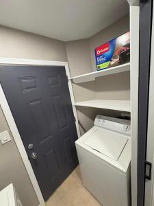 a small laundry room with a door and a washer at 1 BR 1 Bath Airport SpaceX LNG WashDry Yard Patio Pets in Brownsville