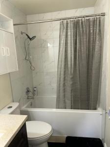 a bathroom with a toilet and a shower curtain at Joyful Home Regina in Regina +29 photos