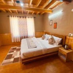 a bedroom with a large bed in a room at Green Tara Mud House by StayApart in Kaza +8 photos