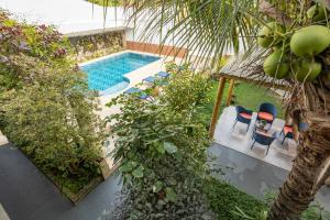 an overhead view of a swimming pool with chairs and trees at Barlavento Villas Chalés e Suites in Ilhabela