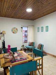 a living room with a wooden table and blue chairs at El Depa 5 - Cerca de todo- in Eldorado