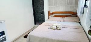 a bedroom with a bed with two stuffed animals on it at Hospedaria Oliveira - São Thomé das Letras in São Thomé das Letras