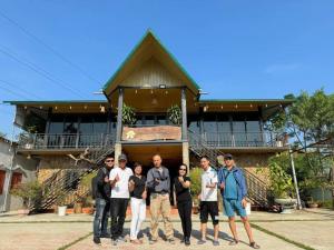 a group of people standing in front of a house at Hải Long Homestay in Làng Chan Han