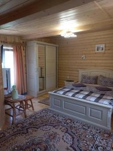 a bedroom with a large bed in a log cabin at Sadyba Medova nasoloda in Guta