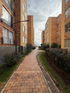 a brick path between two tall buildings at Confort 203 Apartamento Duitama in Duitama +10 photos