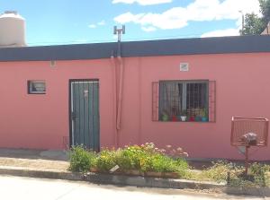 a pink building with a door and a window at Teros in Caleta Olivia