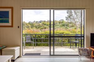 a room with a sliding glass door to a deck at Sur la Mer Onetangi in Waiheke Island