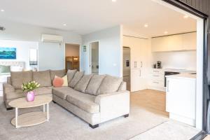 a living room with a couch and a kitchen at Nikau Grove in Waiheke Island
