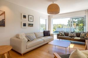 a living room with a couch and a table at Kiwi Street Retreat in Waiheke Island
