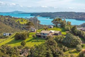an aerial view of a house on a hill with a lake at Woodside Bay Estate in Waiheke Island