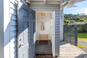 une porte d'entrée d'une maison avec un porche dans l'établissement Driftwood Cottage, à Waiheke Island