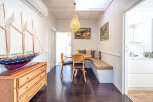 une salle à manger avec une table et des voiliers au mur dans l'établissement Driftwood Cottage, à Waiheke Island