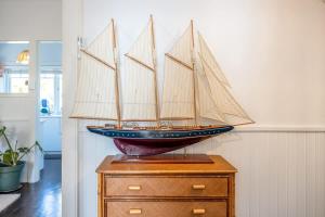 un bateau modèle au-dessus d'une commode dans l'établissement Driftwood Cottage, à Waiheke Island