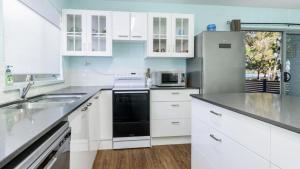 BongareeにあるCharm and Comfort in this Ground floor unit with water views! Welsby Pde, Bongareeのシンクと冷蔵庫を備えた白いキッチン