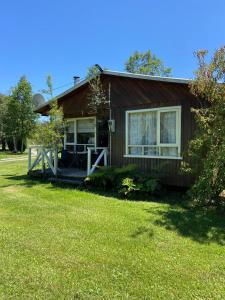 a small house with a porch and a yard at Cabañas Campestres Villarrica in Villarrica