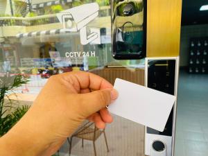 a hand holding a white piece of paper at Jomstay Hostel in Pattaya South