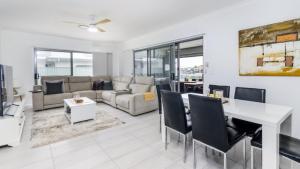 een woonkamer met een bank en een tafel bij Relax Poolside By The Canal in Bongaree