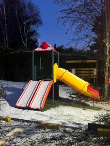 a playground with a yellow and red slide at Hermosas Cabañas con vista al Nahuel Huapi in San Carlos de Bariloche