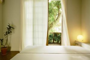 a bedroom with a bed and a large window at Pyoseon Mansion in Seogwipo