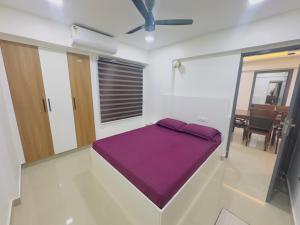 トリバンドラムにあるFully furnished 2BHK Thiruvananthapuram centralの紫の毛布が備わるドミトリールームのベッド1台分です。
