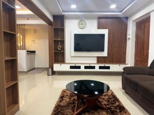 トリバンドラムにあるFully furnished 2BHK Thiruvananthapuram centralのソファとテレビのあるリビングルーム