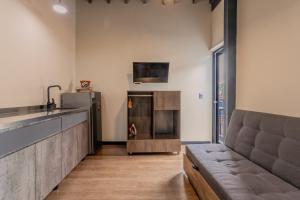 a living room with a couch and a kitchen at Soy Local Parque La 93 in Bogotá