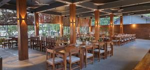 a dining room with wooden tables and chairs at Riviera Resort in Batticaloa