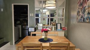 a dining room table with a vase of flowers on it at Cozy Home Deca Clark in Angeles