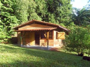 una pequeña cabaña de madera en medio de un campo en Suital Lodge, en Mogos