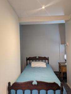 a small bedroom with a bed with a blue blanket at Huaraz chill spot Private room Shared bathroom Cerca del Centro in Huaraz