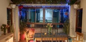 a dining room with a table and a window with christmas lights at Huaraz chill spot Private room Shared bathroom Cerca del Centro in Huaraz