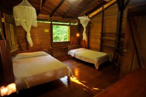 1 dormitorio con 2 camas y ventana en Suital Lodge, en Mogos