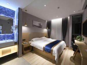 a bedroom with a bed and a desk and a television at Shell Hotel Shanghai Normal University Hongcao Road Metro Station Guiping Road in Shanghai