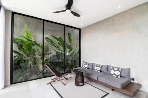 a living room with a couch and a ceiling fan at Balenji Villa by BaliSuperHost in Munggu