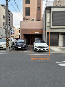 two cars are parked in a parking lot at エレガンス表町-市内中心部でアクセス良好 ワンフロア貸し切りでパーティもOｋ駐車料金無料 in Okayama