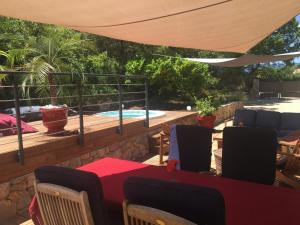 a patio with a table and chairs and a swimming pool at Bulle d'amour in Montauroux