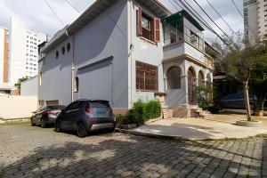 a car parked in front of a white house at Casa Ibirapuera - Hospedagem Domiciliar in Sao Paulo