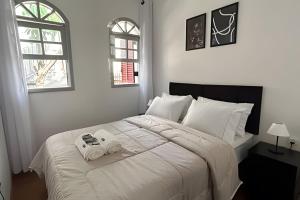 a bedroom with a white bed with two folded towels at Casa Ibirapuera - Hospedagem Domiciliar in Sao Paulo