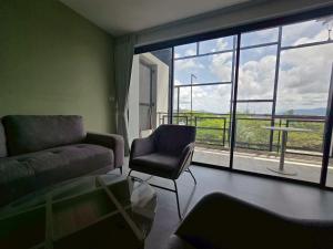 Laguna PhuketにあるLoft condo in Laguna Phuketのリビングルーム(ソファ、椅子、窓付)