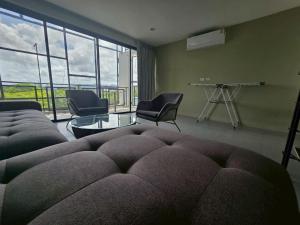 Laguna PhuketにあるLoft condo in Laguna Phuketのソファと椅子とテーブルのあるリビングルーム