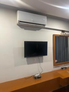TV de pantalla plana en una pared junto a una mesa en Arcadian luxury Apartment, en Rawalpindi