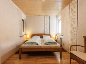 a small bed in a room with two lamps at Ferienwohnungen Bäumner in Bad Berleburg